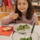 French girl eating salad at school cafeteria