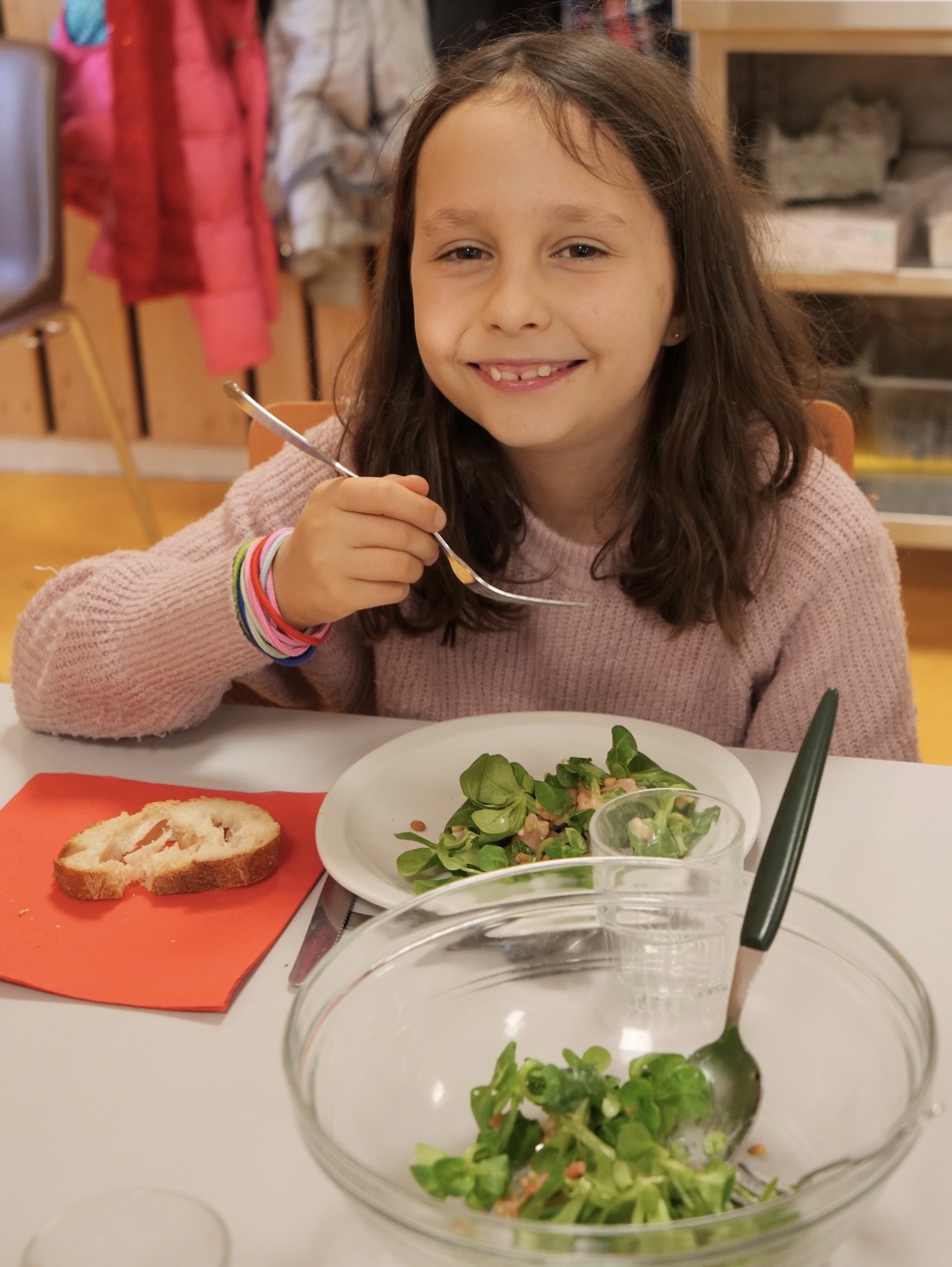 French girl eating salad at school cafeteria