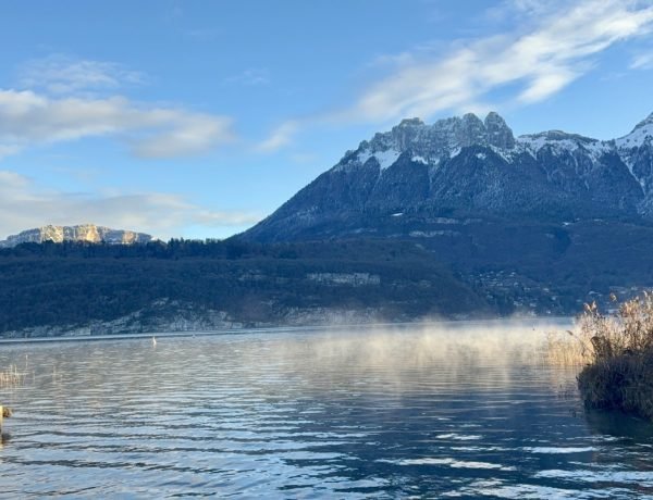 Lake Annecy with mountains in background on winter morning before cold water swimming session.