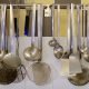 An assortment of hanging utensils on wall of French school cafeteria kitchen.